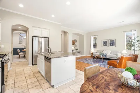 a large living room with stainless steel appliances kitchen island granite countertop a couch and a view of living room