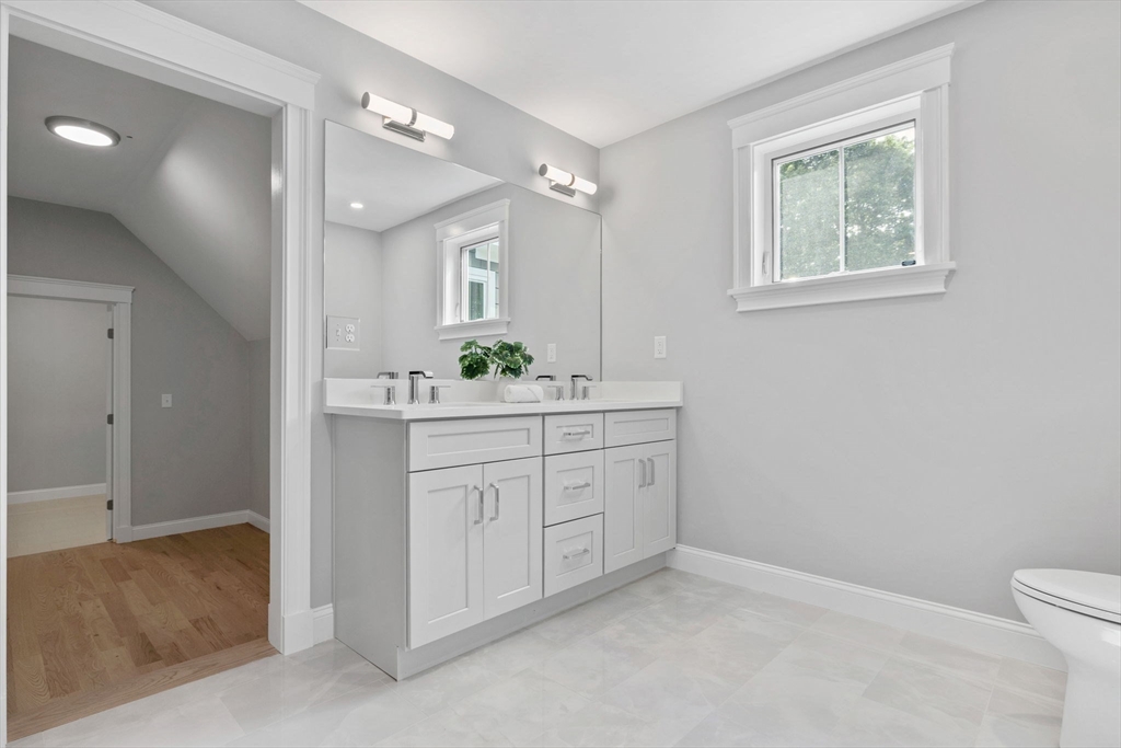 73 R Knoll Street, Unit 73R Boston, MA 02131 - Photo 7 of 11 a bathroom with a sink toilet vanity and a mirror