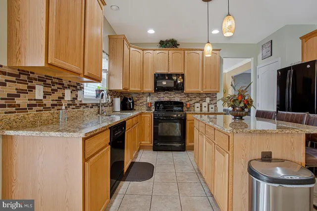 a kitchen with stainless steel appliances granite countertop a sink a stove and a refrigerator
