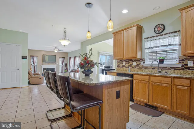 a kitchen with stainless steel appliances kitchen island granite countertop a stove a sink a dining table and chairs