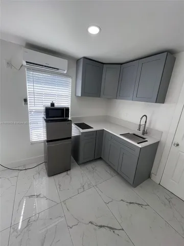 a kitchen with stainless steel appliances a sink a stove a microwave a sink a refrigerator and cabinets