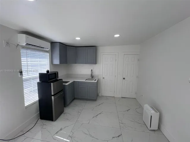 a kitchen with a sink a refrigerator and cabinets