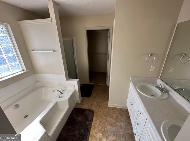 a bathroom with a tub sink and mirror