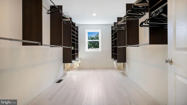 a view of walk in closet with clothes and shoes