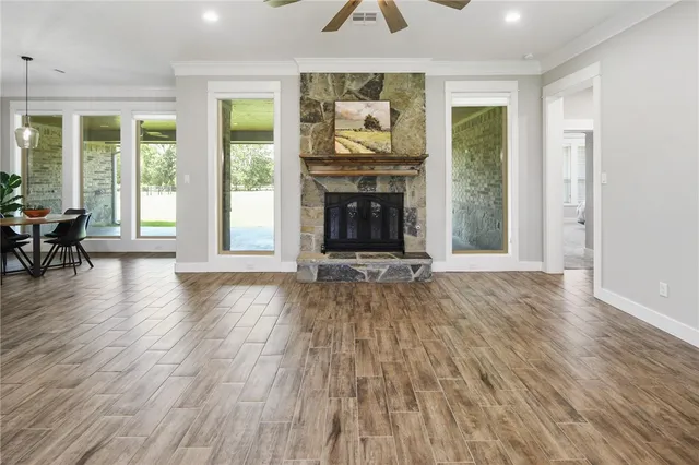 wooden floor fireplace and windows in an empty room