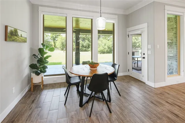 a dining room with furniture a chandelier and wooden floor