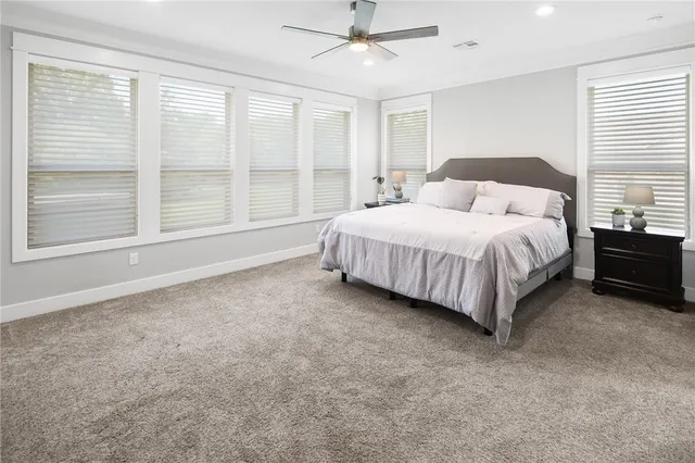 a spacious bedroom with a bed lamp and a large window