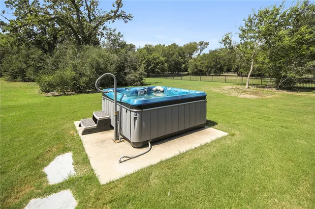 a view of a swimming pool with a yard and sitting area