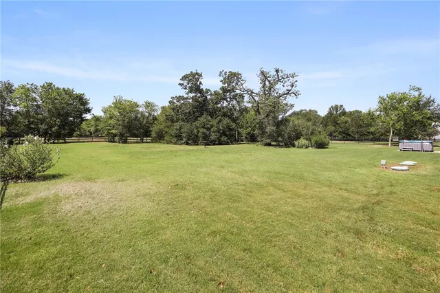 a view of a field with trees in the background