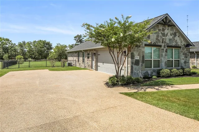 a front view of a house with a yard and potted plants