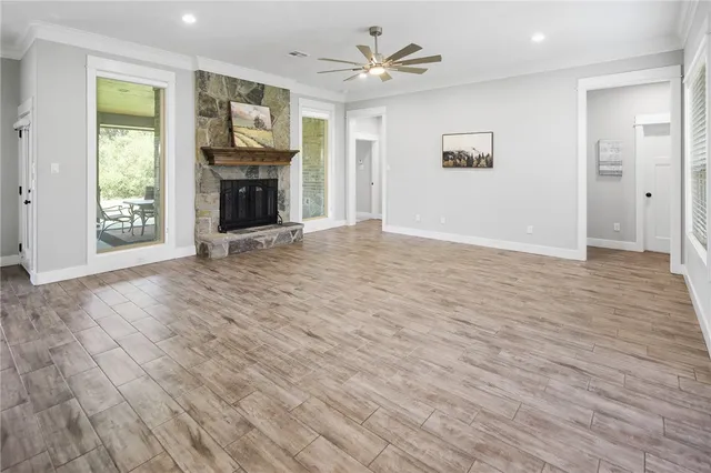 an empty room with windows fireplace and a sink