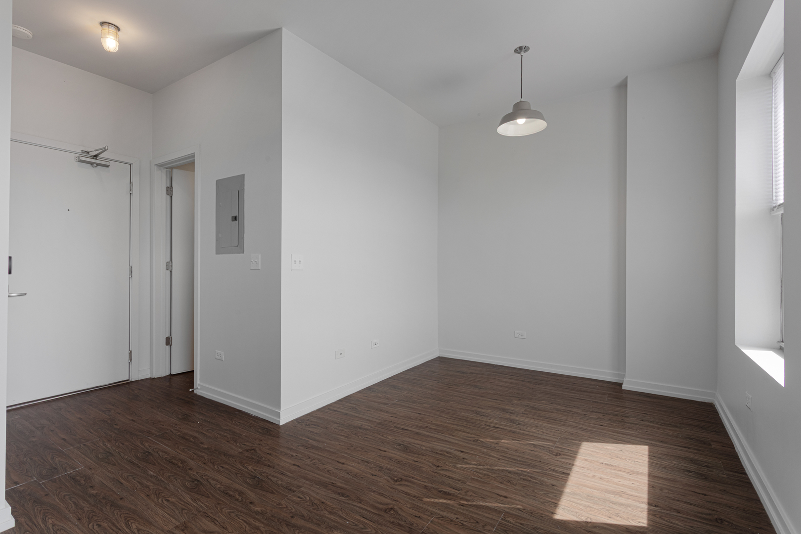 1325 West Wilson Avenue, Unit 1103 Chicago, IL 60640 - Photo 4 of 12 a view of a room with wooden floor and white walls