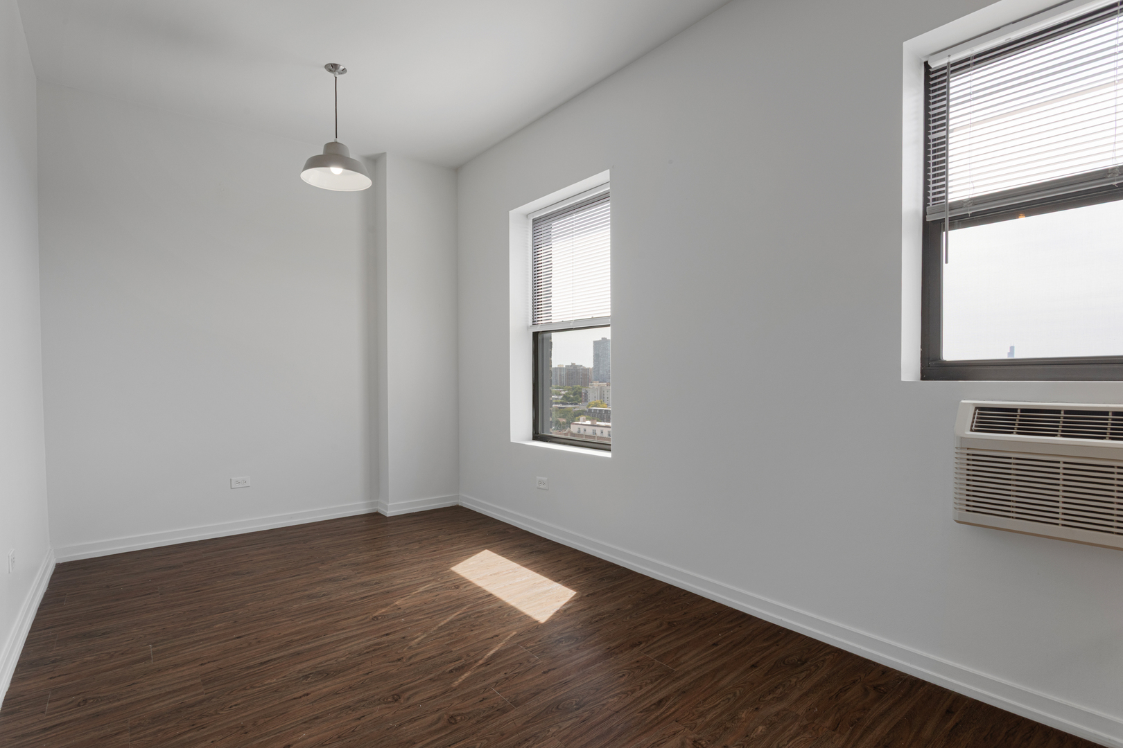 1325 West Wilson Avenue, Unit 1103 Chicago, IL 60640 - Photo 5 of 12 a view of an empty room with wooden floor and a window