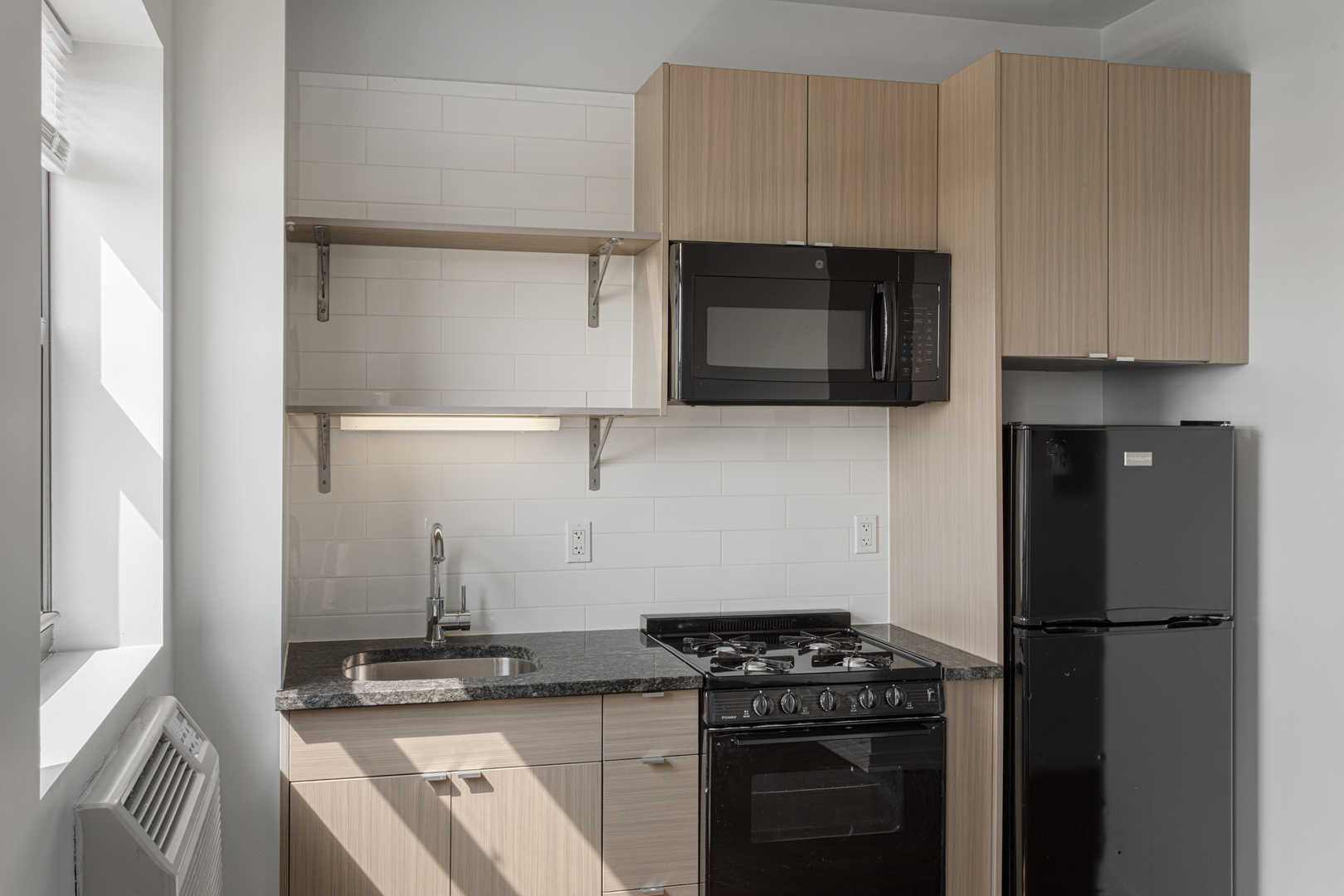 1325 West Wilson Avenue, Unit 1103 Chicago, IL 60640 - Photo 6 of 12 a kitchen with a stove and a microwave