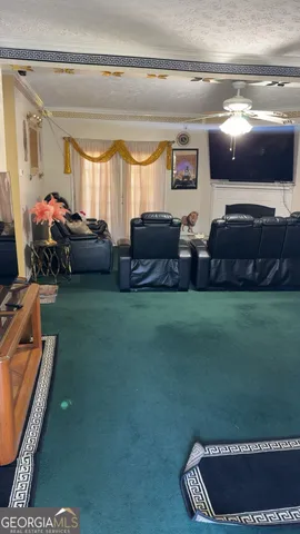 a living room with furniture a flat screen tv and a window