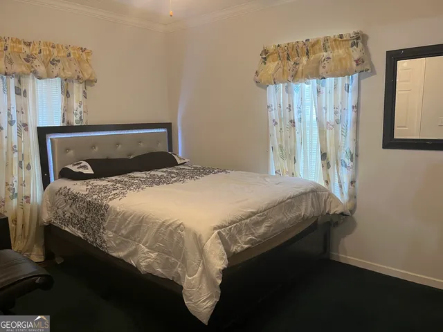 a bed sitting in a bedroom next to a bathroom