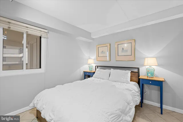 a bedroom with a bed and a flat tv screen on wall