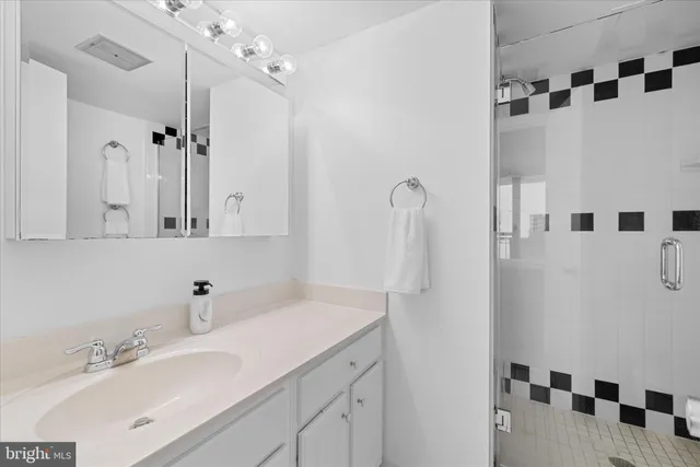 a bedroom with a bed and a large mirror on the dresser