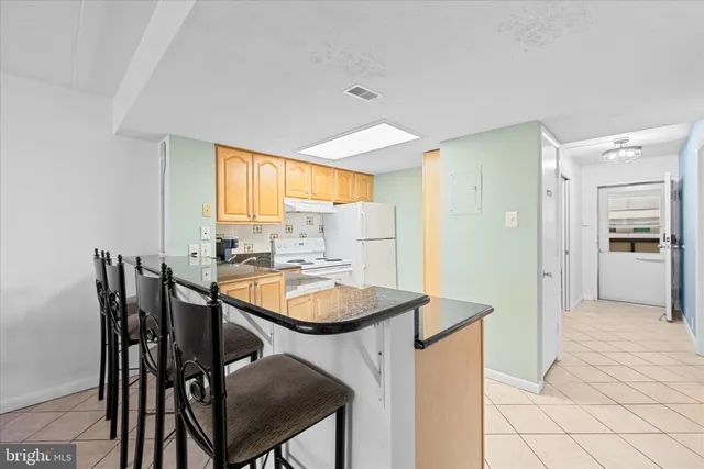 a kitchen with stainless steel appliances granite countertop a sink and a white cabinets