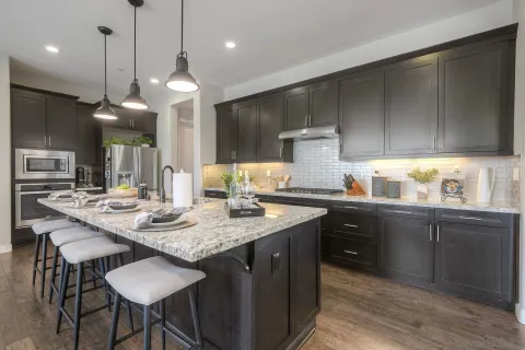 a kitchen with a dining table cabinets and wooden floor