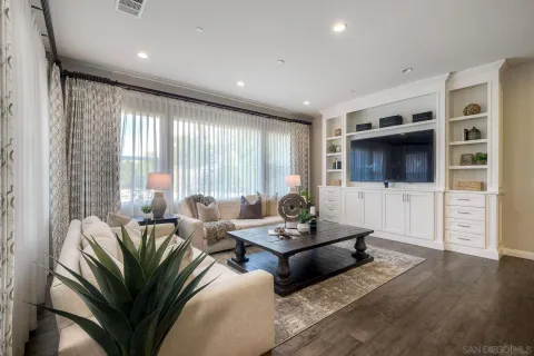 a living room with furniture a flat screen tv and a large window