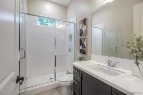 a bathroom with a granite countertop sink toilet and shower