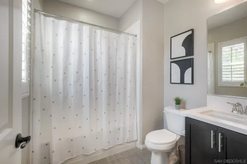 a bathroom with a granite countertop toilet and a sink