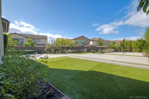 a view of a house with a yard and table and chairs under an umbrella