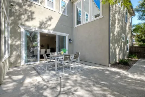 a view of a patio with table and chairs and floor to ceiling window