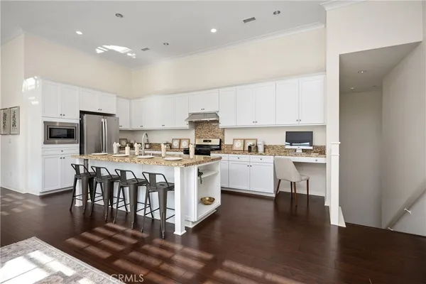 a kitchen with white cabinets and stainless steel appliances