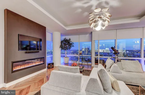 a living room with furniture a chandelier and a flat screen tv