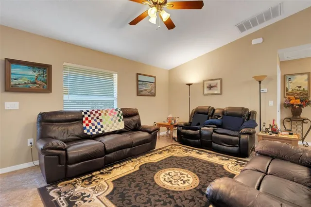 a living room with furniture ceiling fan and a rug