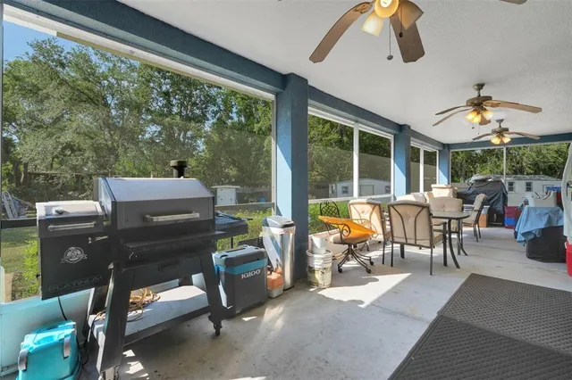 a living room with patio furniture and a floor to ceiling window