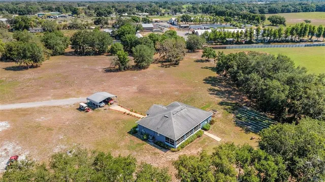 an aerial view of a house with a yard and lake view