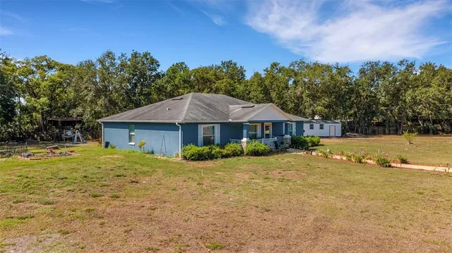 a front view of a house with yard and trees