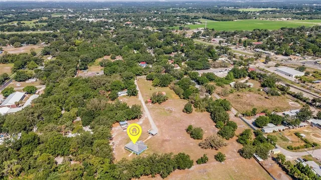 an aerial view of a house with a yard and lake view