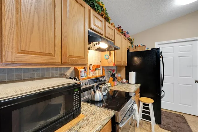 a kitchen with stainless steel appliances granite countertop a stove a sink and a refrigerator