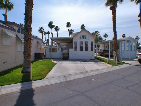 a front view of a house with a garden and yard
