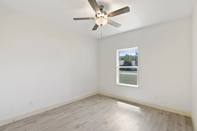 an empty room with a window and a fan