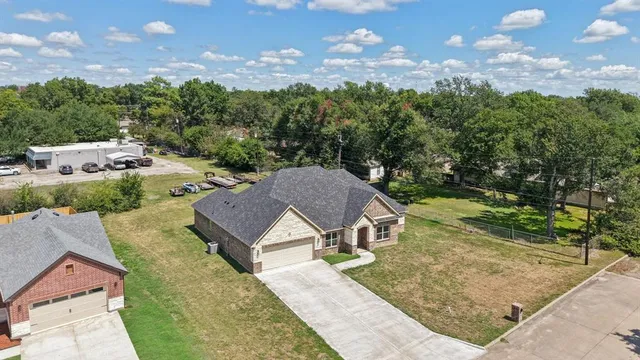 an aerial view of a house with yard and green space