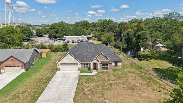 a aerial view of a house next to a yard with big trees