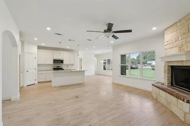 a view of kitchen with stainless steel appliances kitchen island wooden floor and living room view