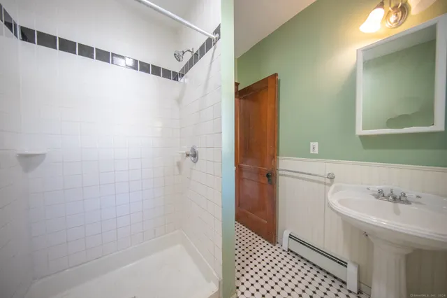 a bathroom with a sink a shower and a mirror