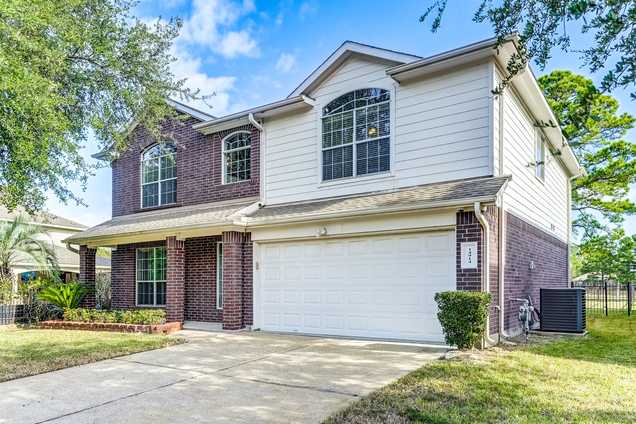 14914 Forest Enclave Lane Houston, TX 77068 - Photo 2 of 49 a front view of a house with garden and plants