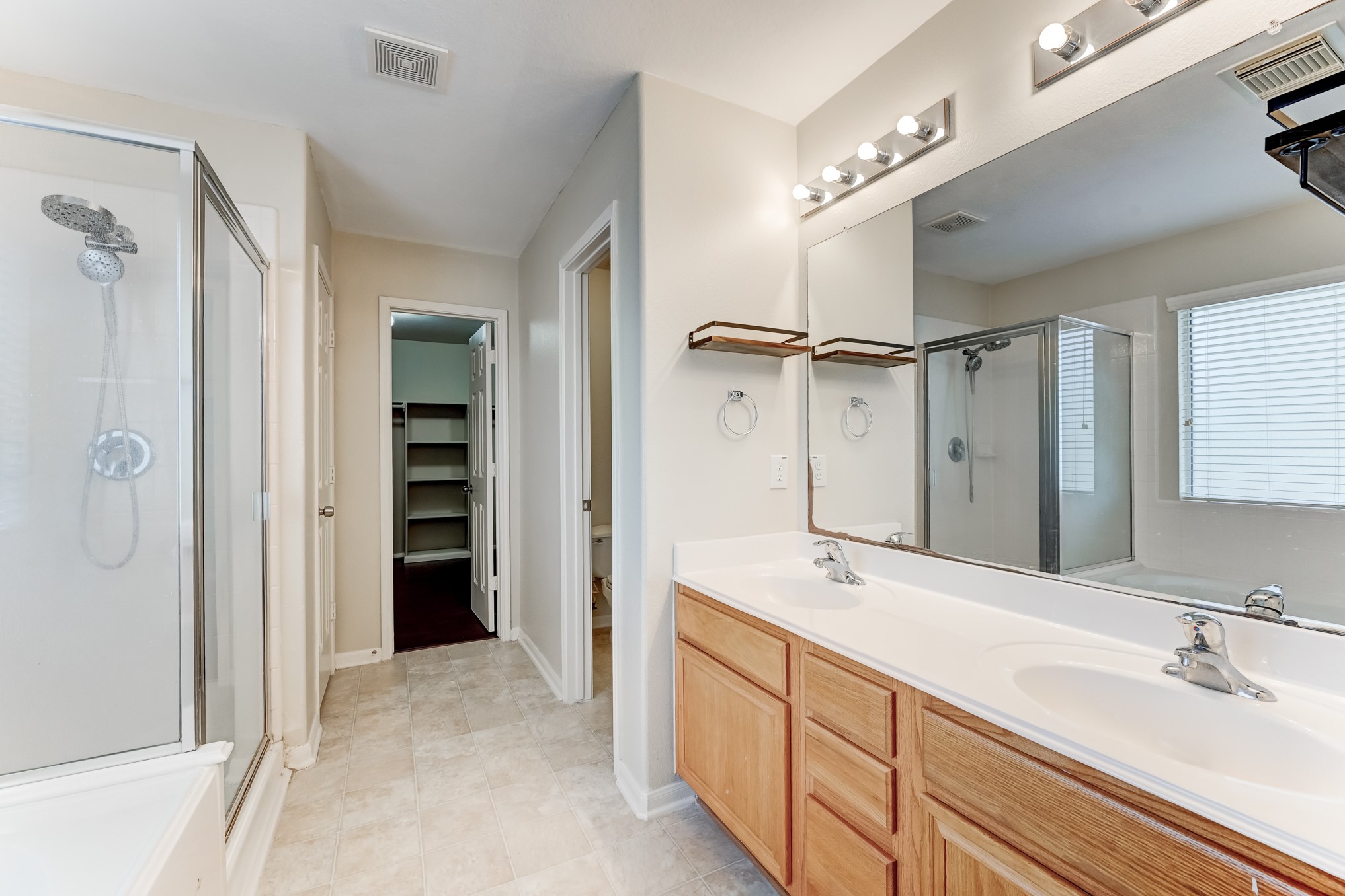 14914 Forest Enclave Lane Houston, TX 77068 - Photo 28 of 49 a spacious bathroom with a shower sink and a mirror