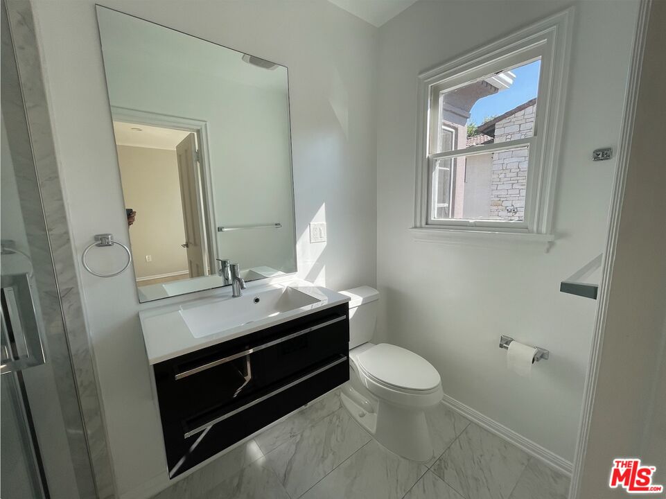 437 Shirley Place, Unit D Beverly Hills, CA 90212 - Photo 13 of 16 a bathroom with a sink a toilet and a window