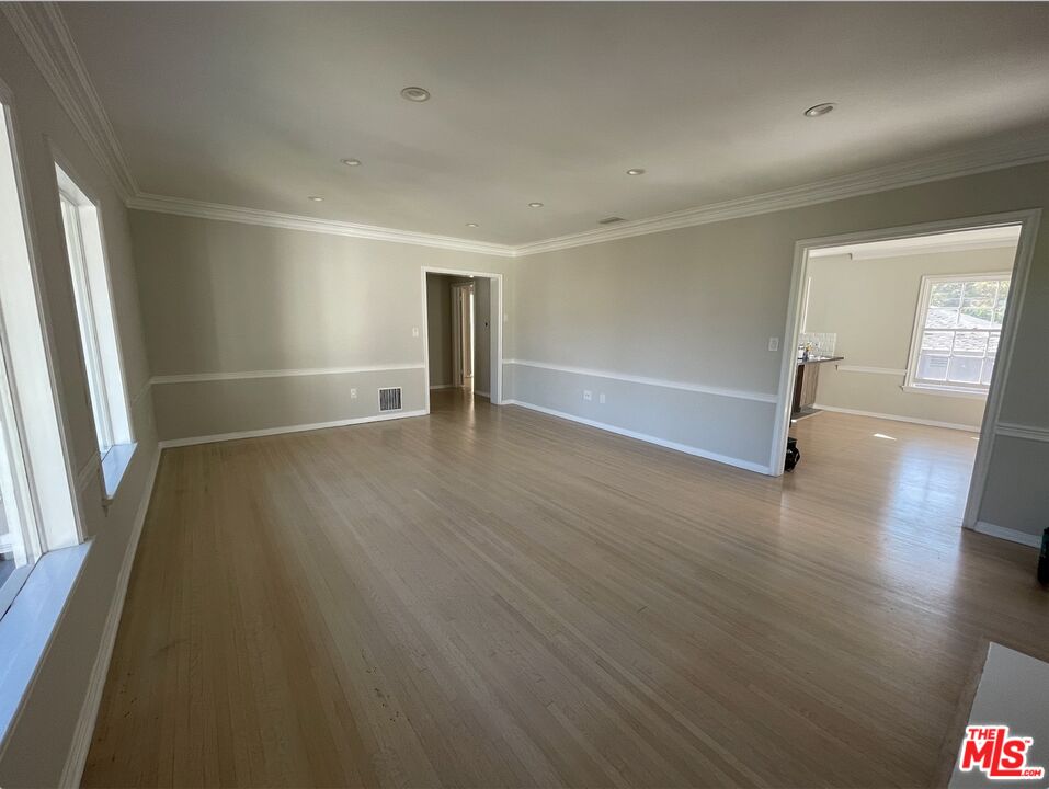 437 Shirley Place, Unit D Beverly Hills, CA 90212 - Photo 3 of 16 an empty room with wooden floor and windows