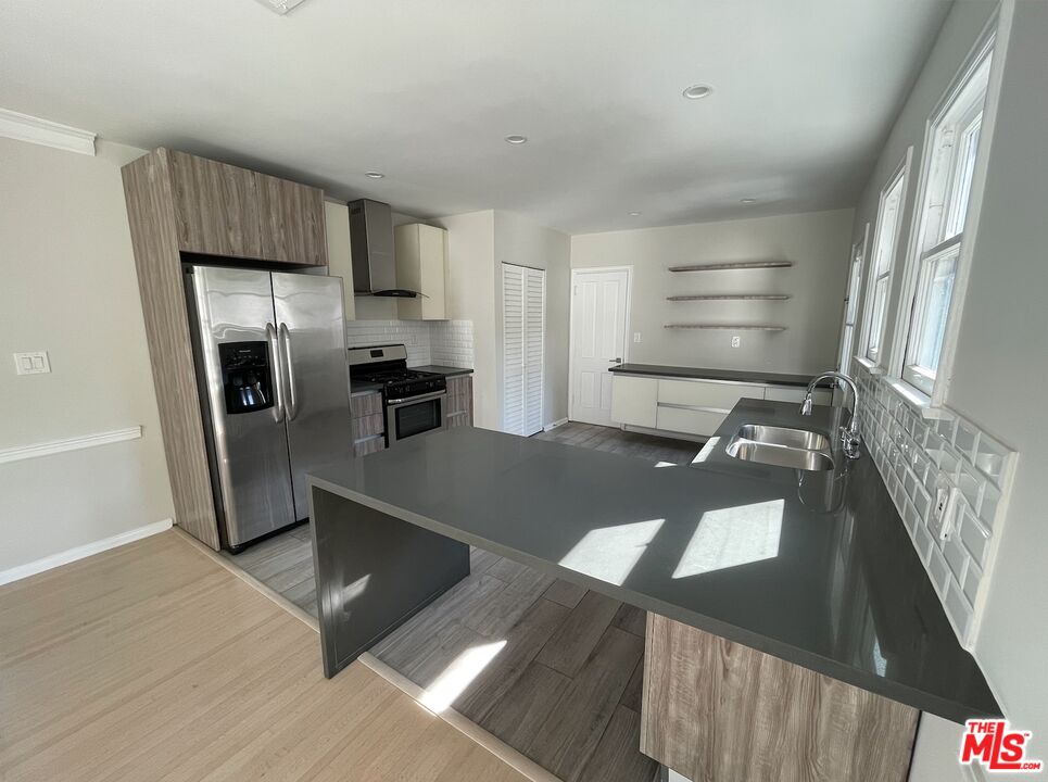 437 Shirley Place, Unit D Beverly Hills, CA 90212 - Photo 4 of 16 a view of a kitchen with fridge and wooden floor
