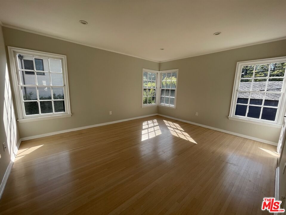 437 Shirley Place, Unit D Beverly Hills, CA 90212 - Photo 8 of 16 a view of empty room with wooden floor and fan