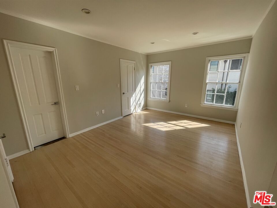 437 Shirley Place, Unit D Beverly Hills, CA 90212 - Photo 10 of 16 an empty room with wooden floor and windows